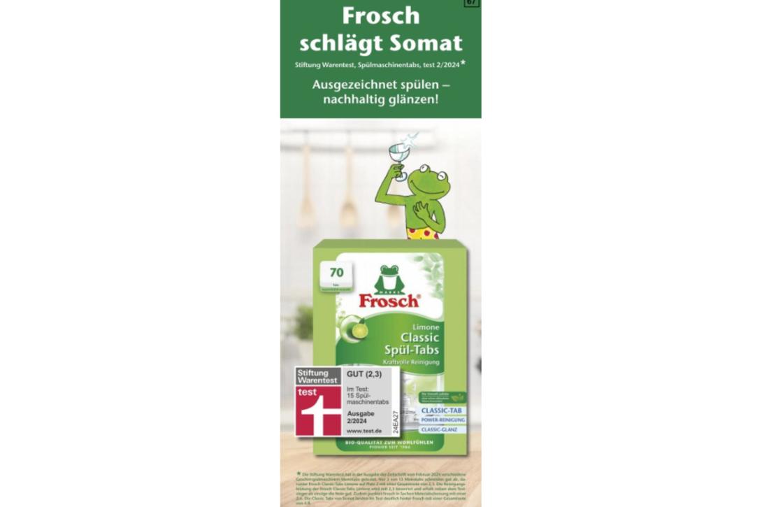 Eine Werbeanzeige, in der oben der Slogan "Frosch schlägt Somat" steht, darunter ein Sternchenhinweis mit Verweis auf Ergebnisse der Stiftung Warentest sowie ein Bild des Markenmaskottchens, eines gezeichneten Frosches, der ein blinkendes Glas hält, und eine Abbildung der Produktverpackung.